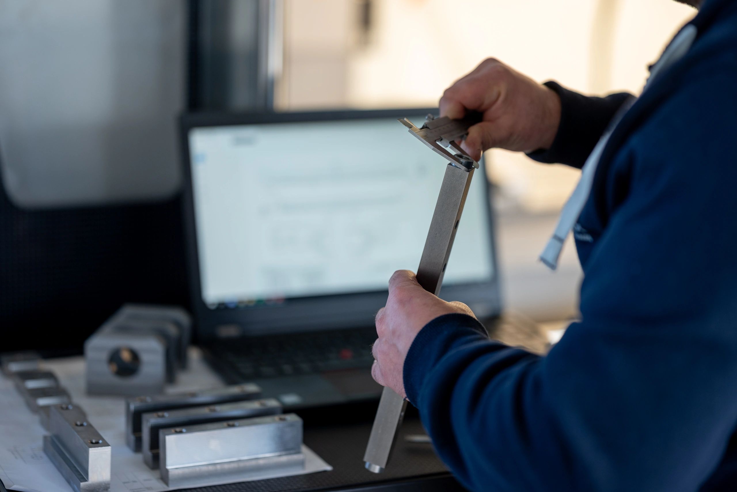Engineer measuring a machined part with a vernier caliper